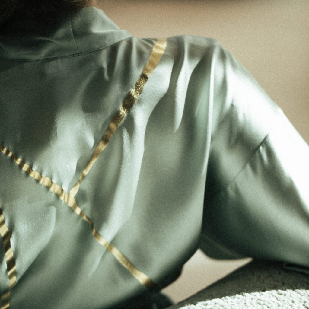 close up of silk kimono in sage with gold detailing