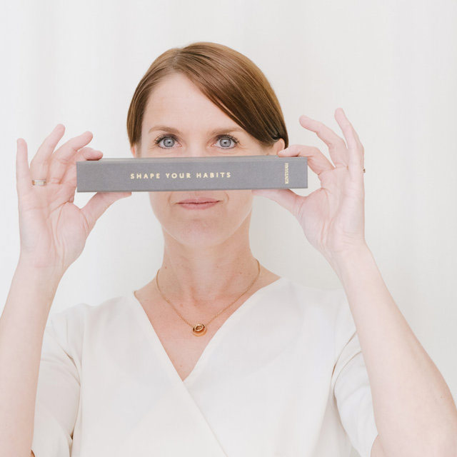 Woman holding a product in front of her face