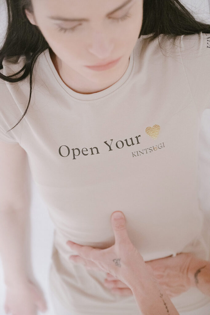 Woman wearing a Kintsugi t-shirt that says 'Open your heart'