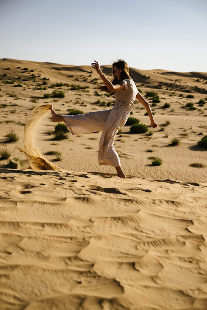 Woman dancing on the beach, having a great time