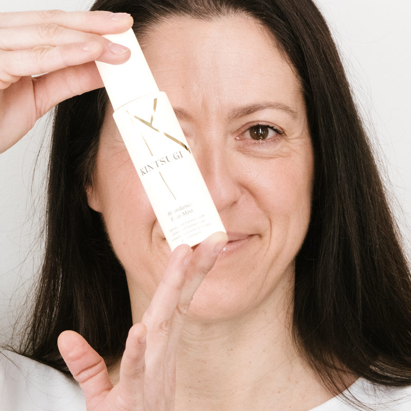 Woman holding the face mist over her face