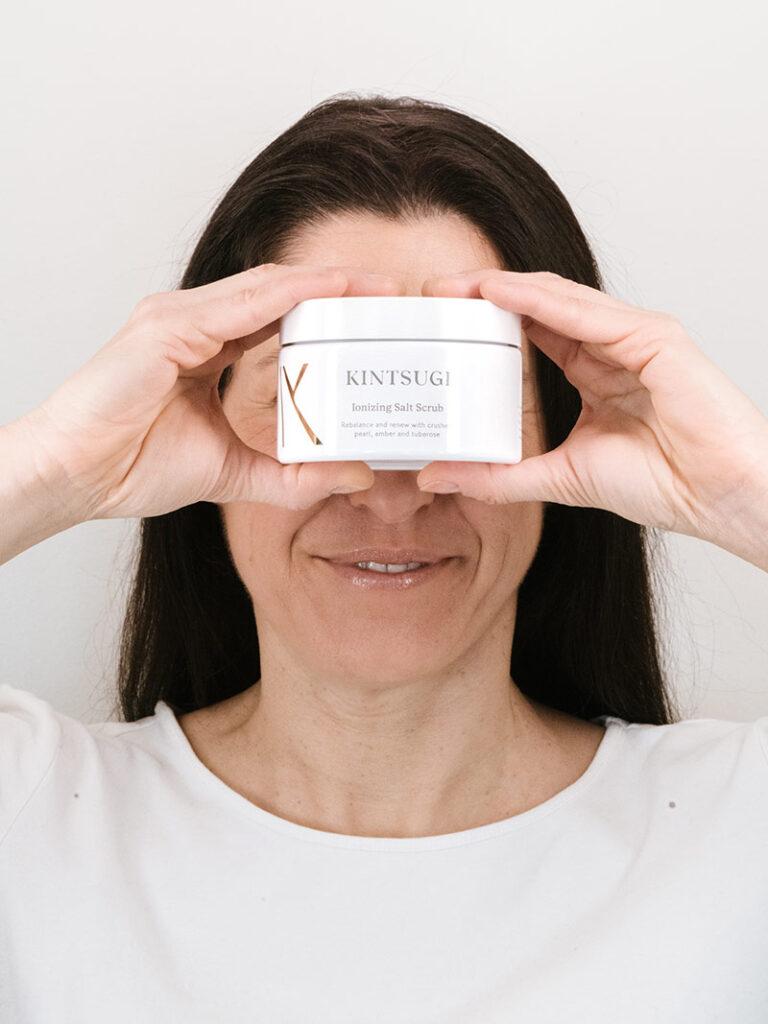 Woman holding Kintsugi salt scrub over her face