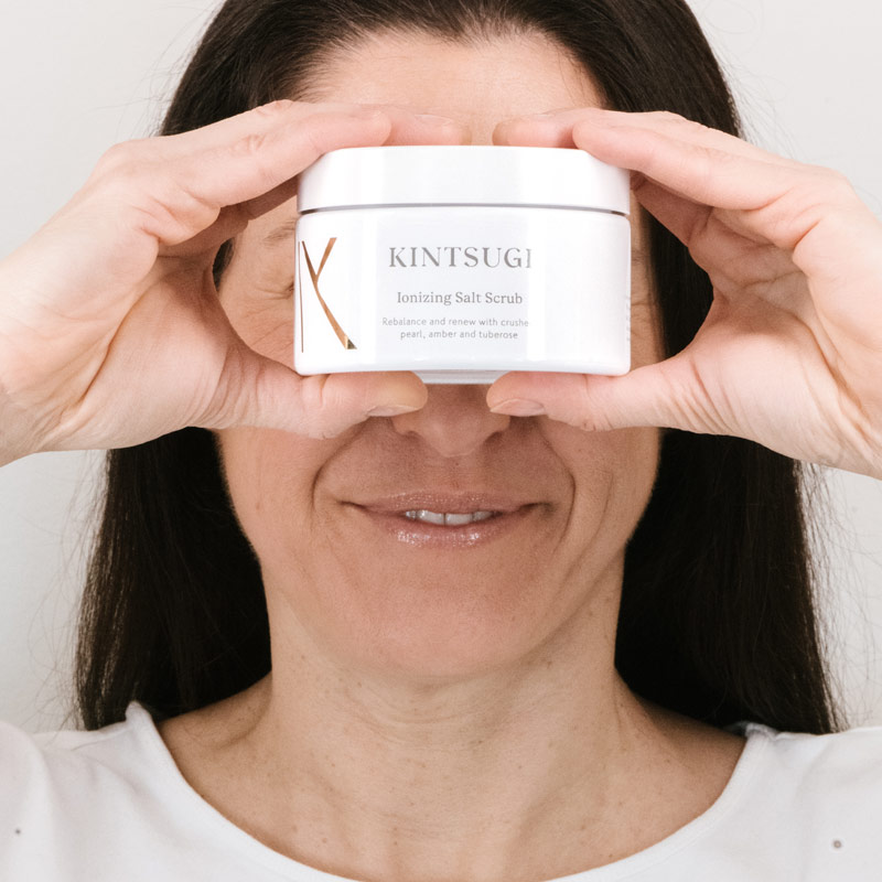 Woman holding the salt scrub over her eyes